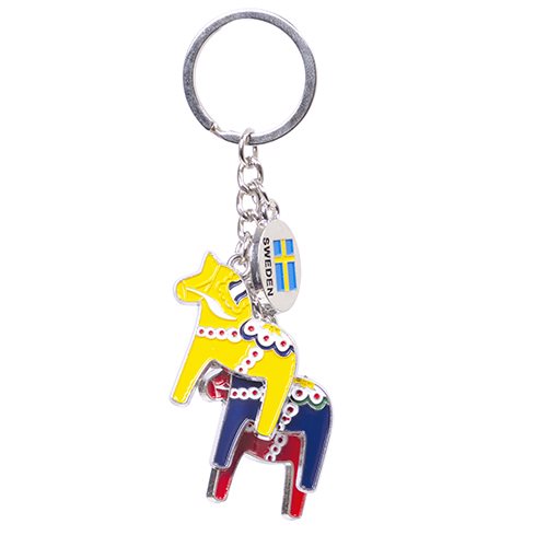 Keychain featuring two dala horse charms in yellow and blue with dotted accents, accompanied by a small metal plate adorned with the Swedish flag and the word "Sweden.