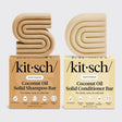 Two beige solid bars, shaped as S and D, sit atop boxes labeled "Hair: Coconut Oil Shampoo & Conditioner Bar Combo for Dry Damaged Hair 2 2.7oz Bars by Kitsch.
