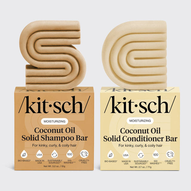Two beige solid bars, shaped as S and D, sit atop boxes labeled "Hair: Coconut Oil Shampoo & Conditioner Bar Combo for Dry Damaged Hair 2 2.7oz Bars by Kitsch.