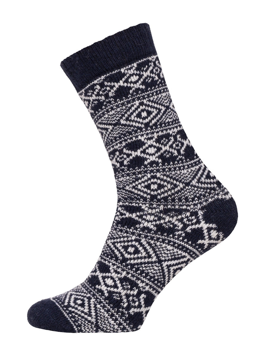 The product displayed is a single sock from the Norwegian Wool Socks collection in navy blue, adorned with a white knitted geometric pattern consisting of diamonds and lines. Made from recycled wool, this winter sock provides both warmth and sustainability.