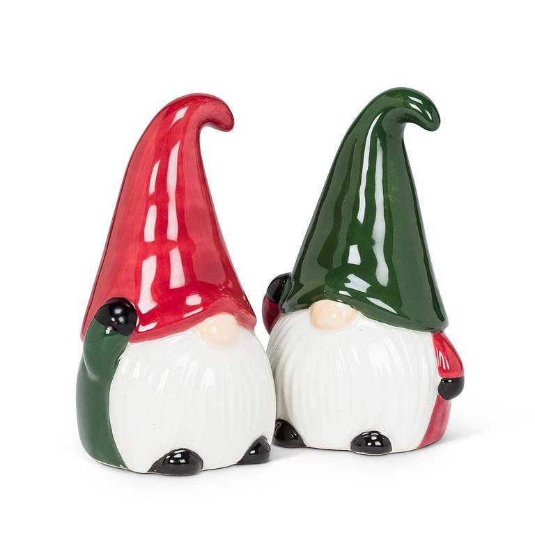 Two ceramic Nisse/Gnome figurines, beautifully crafted as salt and pepper shakers, display tall hats with one in festive red and the other in vibrant green, standing side by side.