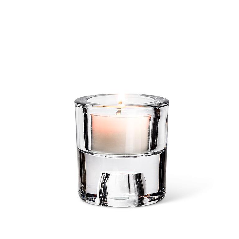 This elegant piece, named the Candle Holder: 2.5" Glass Reversible Taper/Tealight Holder, features a lit candle gracefully resting in a clear glass holder against a white background.