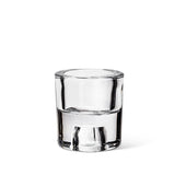 A 2.5" glass reversible taper/tealight holder, which resembles a clear shot glass, is elegantly displayed on a white background.