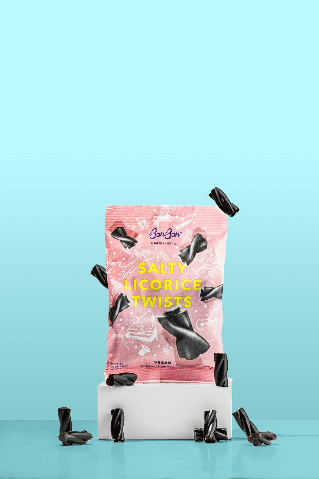 A package of Candy: Salty Licorice Twists (120g), a classic Swedish treat, is placed on a white pedestal with scattered licorice pieces, all set against a light blue background.