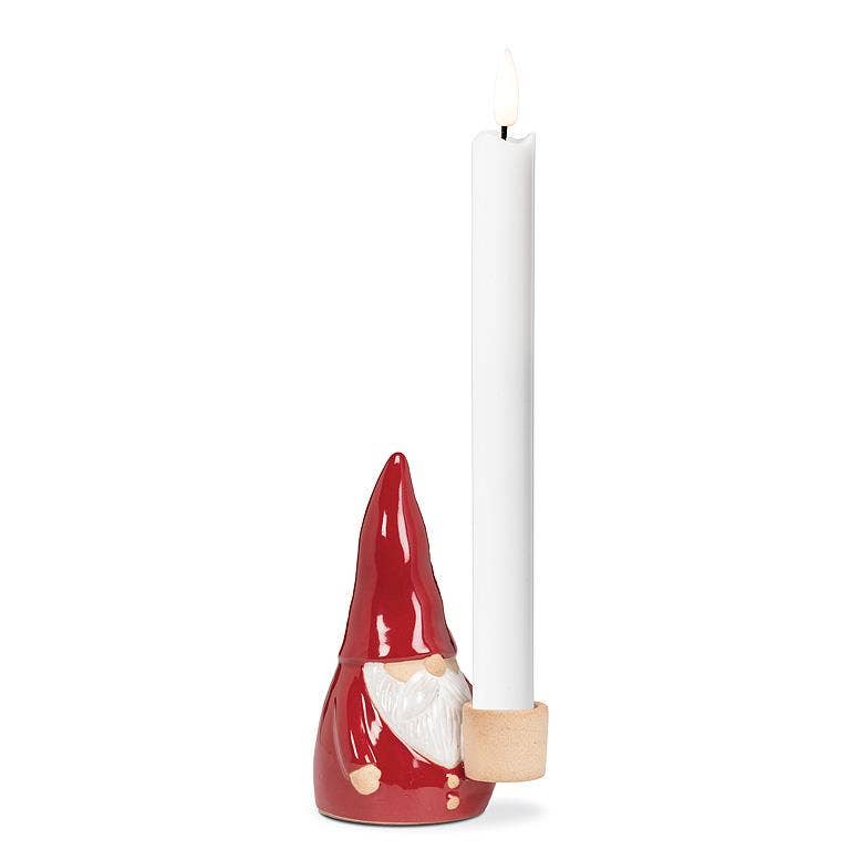 The Tomte Santa Taper Holder (5"H) is a ceramic gnome-like candle holder in festive red, ideal for cradling a white taper candle to enhance your holiday decor.