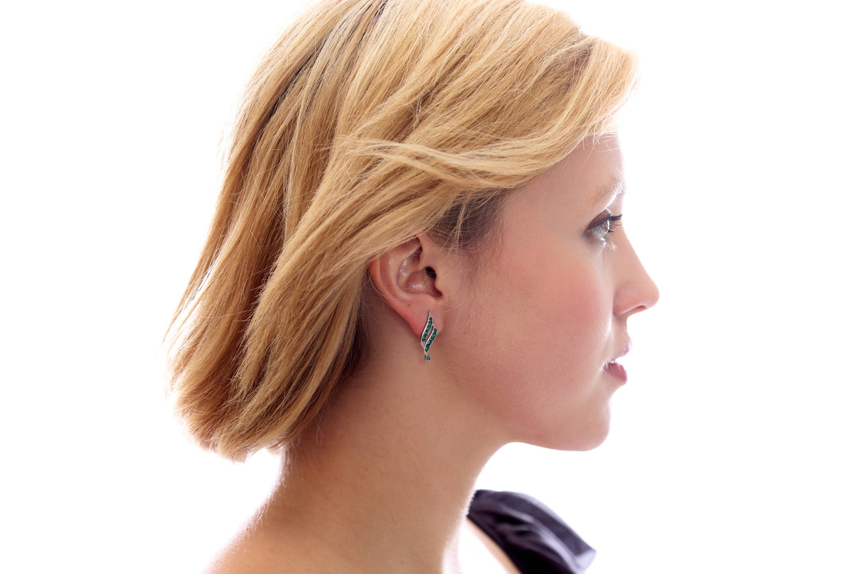 A woman with short blonde hair and a black top is shown in profile against a white background, wearing May Emerald Beautiful Spiral Swarovski® Crystals Silver Earrings.