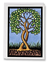 Illustration of two intertwined trees forming a heart with their branches, set against a blue sky and grass with roots. Card: Together Forever Tree by Sarah Angst, 5x7. Part of Sarah Angst Art’s Greeting Card collection. Made in America.