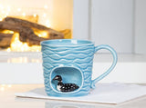 The Wavy Aqua Mug with Loon in Recess (4"H, 14oz) is a handcrafted ceramic mug featuring a loon design in a recessed area—perfect as a nature-inspired gift.