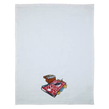 White cloth Scandinavian tea towel featuring a small print of a patterned rug, books, a chest, and eyeglasses—Tea Towel - Guide Book Tea Towel Betty Crocker Recipes—perfect for adding Nordic style to your kitchen.