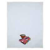 White cloth Scandinavian tea towel featuring a small print of a patterned rug, books, a chest, and eyeglasses—Tea Towel - Guide Book Tea Towel Betty Crocker Recipes—perfect for adding Nordic style to your kitchen.