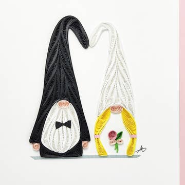 Introducing the "Gnome Wedding Couple" cards: a delightful hand-crafted creation featuring a charming pair of gnomes made from quilled paper. One gnome is adorned in black with a bow tie, while the other exudes elegance in white, holding a bouquet of flowers. This whimsical and elegant design beautifully captures the essence of charm.