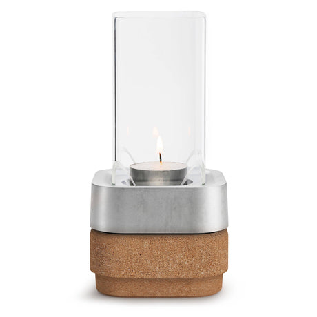 A white candle burns in the Stumpastaken Ettan candle holder, made from 100% recycled material with a white powdercoated finish (8.8x8.8x4 cm), set against a plain white background.