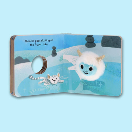 An open finger puppet book featuring a white plush yeti and white tiger on a blue frozen lake, with the text: Then he goes skating on the frozen lake.