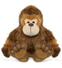 The Plush: Super-Soft Big Foot Stuffed Plush features brown fur, a beige face, and large embroidered feet, sitting upright and facing forward to resemble a charming stuffed Bigfoot cryptid plush toy.