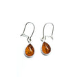 Cognac Amber Sterling Silver Earrings on Hooks featuring teardrop-shaped Baltic amber stones set against a white background.