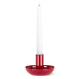 A white taper candle glows in the Small Pipe Taper Holder-Red (2"H), adding striking modern table decor to any plain white background.