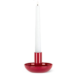 A white taper candle glows in the Small Pipe Taper Holder-Red (2"H), adding striking modern table decor to any plain white background.