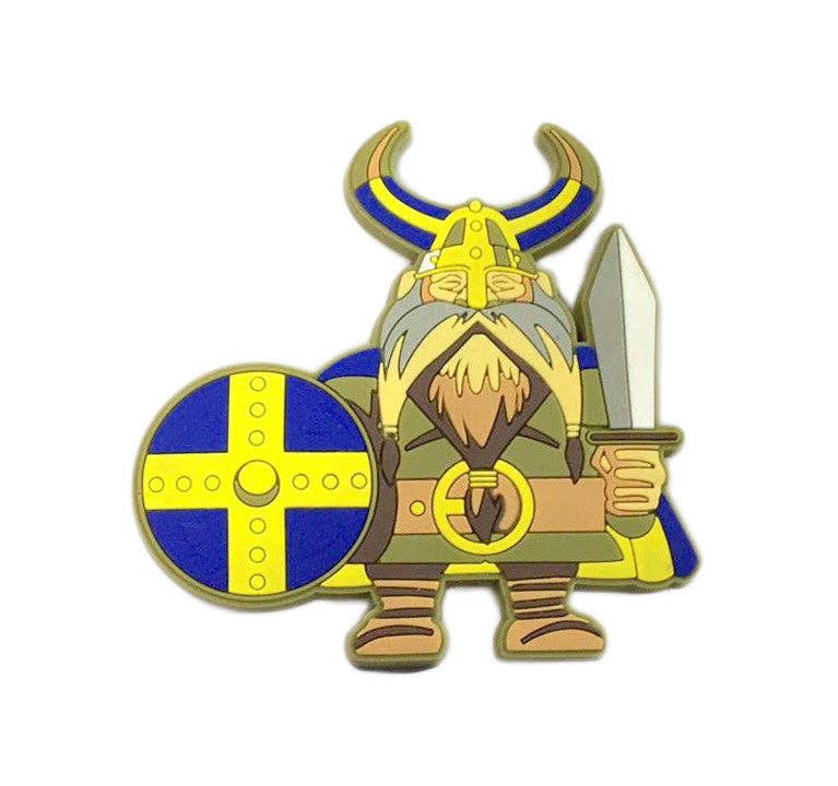 The Magnet: Swedish Viking Scandinavian Kitchen Magnet features a cartoon Viking with a sword, round shield, horned helmet, and blue cape—a fun Nordic addition to any Scandinavian kitchen.
