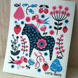 A decorative dish cloth featuring a blue and black Swedish Dala Horse amid stylized flowers, birds, strawberries, and cherries, designed by Swedish artist Lotta Spjute.