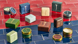 Palo Santo soap bars and candles in various colors and packaging are displayed on blue and red tiled surfaces.