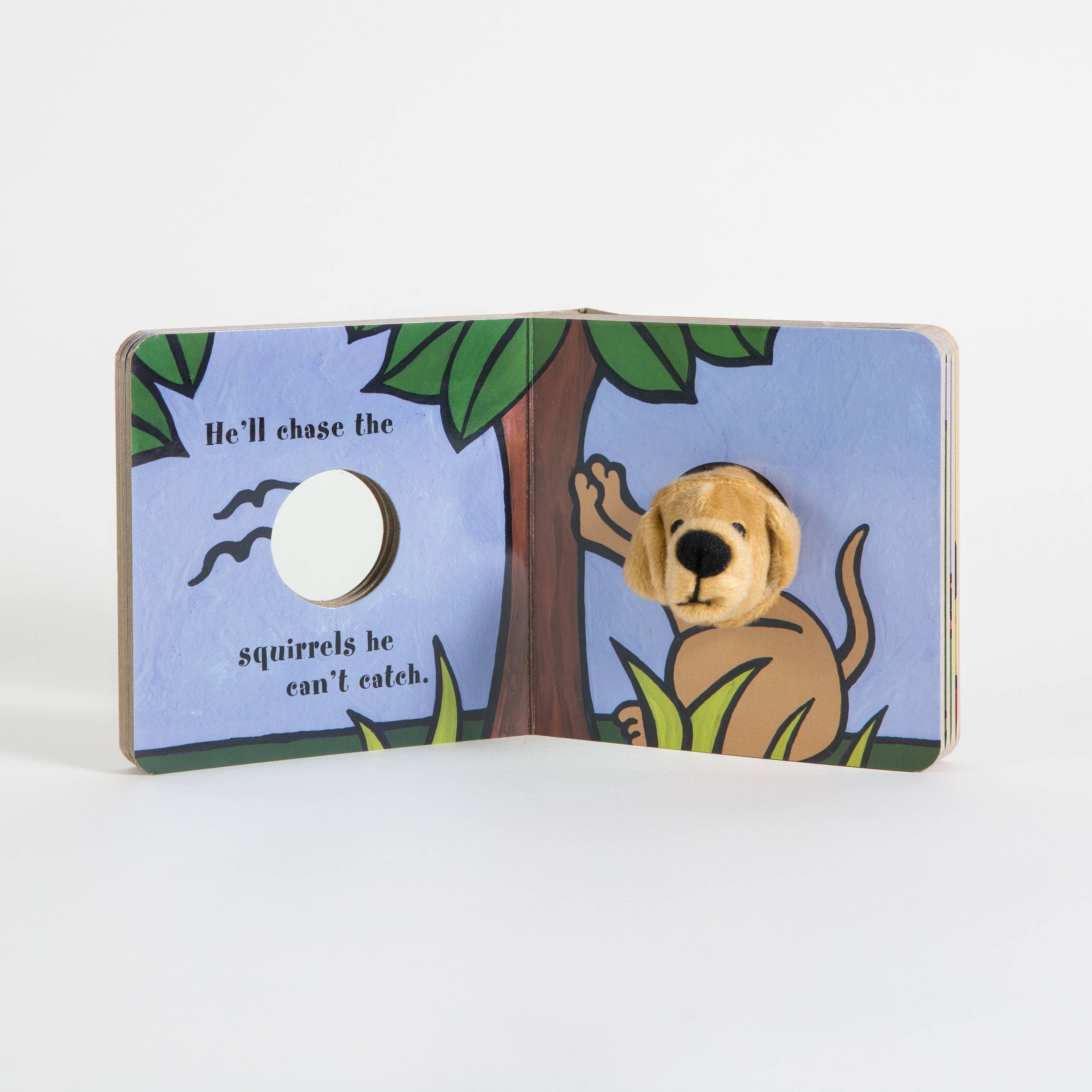 The Little Puppy Finger Puppet Book features a dog illustration by a tree with the text, "He’ll chase the squirrels he can’t catch," and includes an attached small dog puppet for interactive fun.