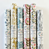 Two glossy sheets of Juniper Blue’s Swedish Dala Horse gift wrap (20" x 29" each) display vibrant designs featuring traditional motifs in rich colors, perfect for adding a festive Scandinavian touch to your presents.