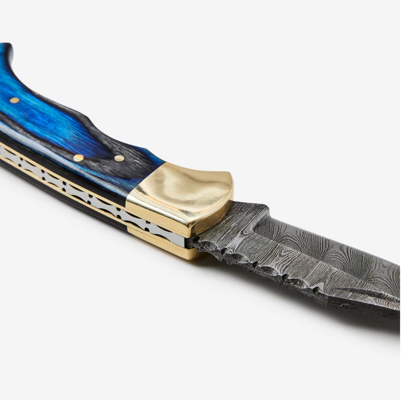 A close-up of the Knife: Blue Diamond Wood Folding Knife w/ Leather Sheath, showcasing its blue wooden handle, brass bolster, and patterned Damascus steel blade.