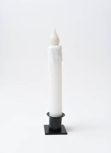 The Candle: Diamond Dusted Christmas LED Timer Taper Candle features melted wax drips and stands upright in a black square holder against a plain white background.