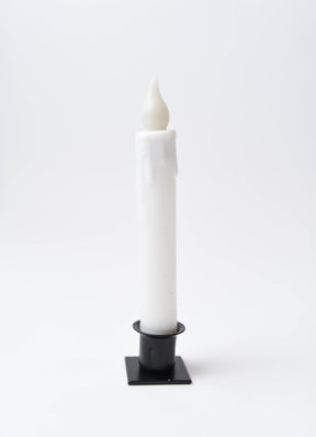 The Candle: Diamond Dusted Christmas LED Timer Taper Candle features melted wax drips and stands upright in a black square holder against a plain white background.