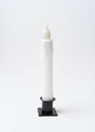 The Candle: Diamond Dusted Christmas LED Timer Taper Candle features melted wax drips and stands upright in a black square holder against a plain white background.