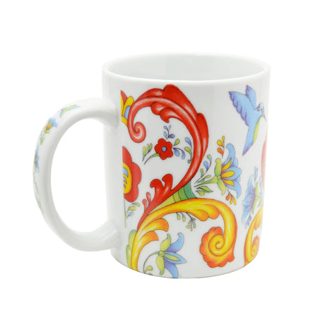 The 12 oz Coffee Mug: Colorful Norwegian Rosemaling features a white ceramic base with vibrant red, yellow, and blue floral and swirl designs, plus a charming blue bird motif.