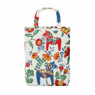 A tote bag showcasing the Swedish Dala Horse in blue and yellow alongside Swedish flowers, all set against a white cotton background, crafted with Arvidssons Textils' renowned attention to detail.