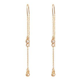 Earrings: A&C Oslo Long Crystal Chain Gold Earrings feature clear round gemstones and delicate gold chains with small dangling elements for a refined, organic look.