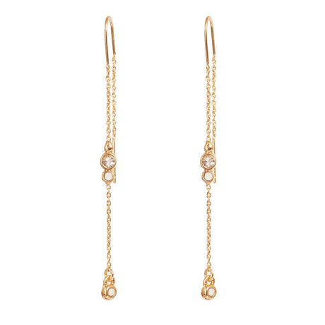 Earrings: A&C Oslo Long Crystal Chain Gold Earrings feature clear round gemstones and delicate gold chains with small dangling elements for a refined, organic look.