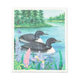 Enjoy beautiful Canadian wildlife at home with the Dish Cloth: Loon Pair on the Lake Swedish Dishcloth-6.75x7.5"L, featuring two loons swimming near a forested shore with vibrant flowers—a perfect eco-friendly addition to your kitchen.