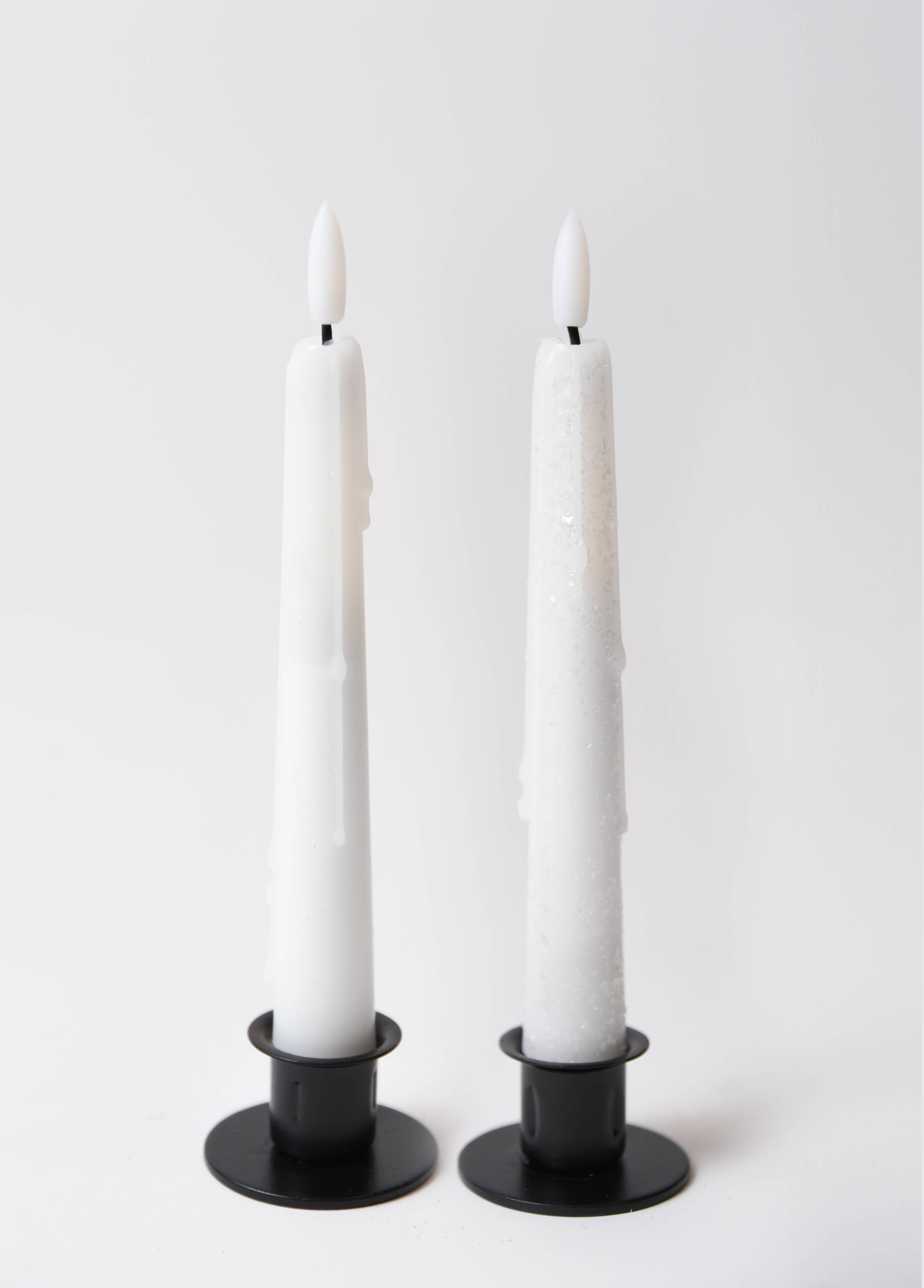 Two Holiday Special Realistic Flame Battery Taper Candles in black holders stand upright against a plain white background. Subtle wax drips add charm—ideal for stylish holiday table decor.
