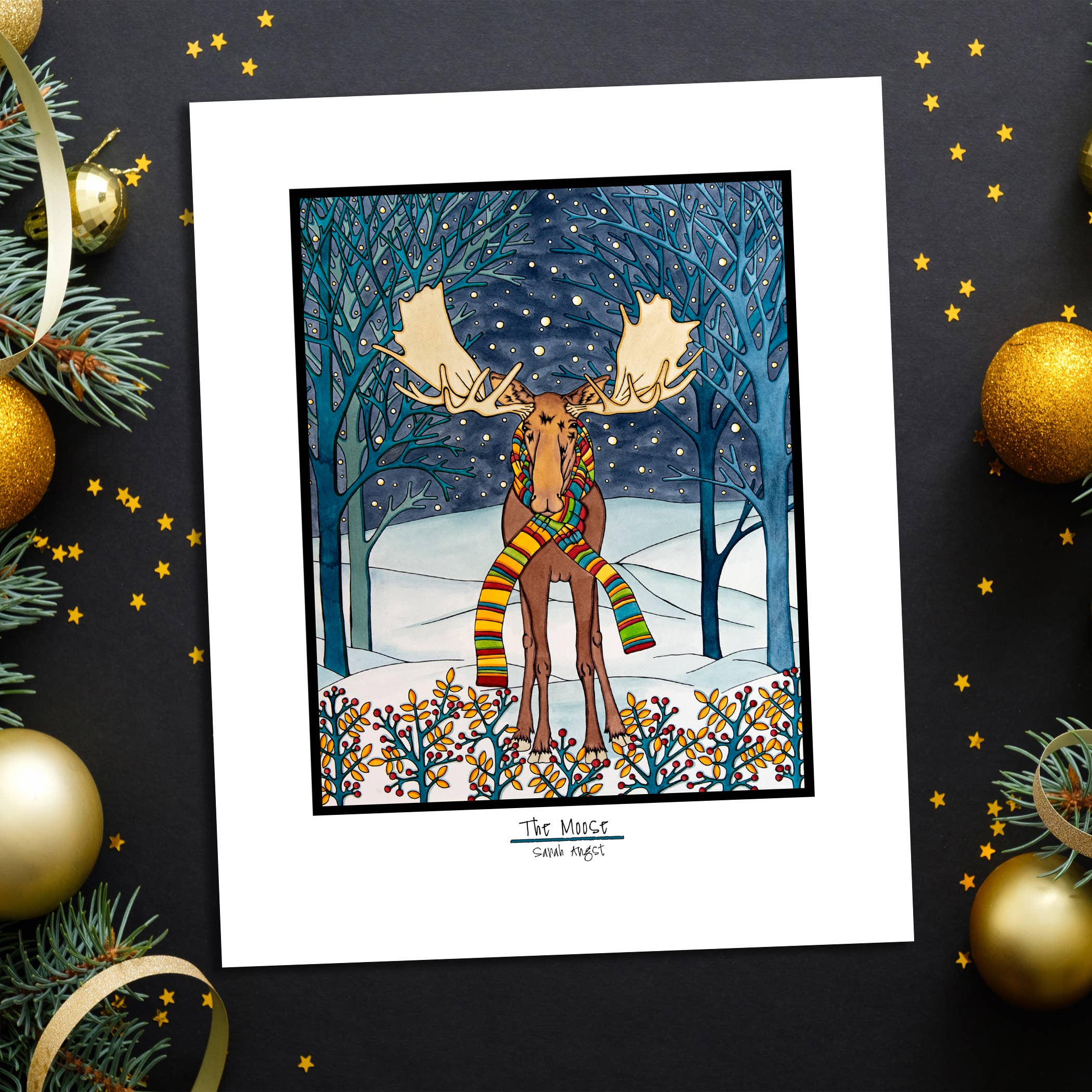 This 8"x10" giclee print, titled "Holiday Moose," depicts a moose adorned with a colorful scarf standing in a snowy forest beneath a starry sky. It's surrounded by festive decorations such as pine branches and gold ornaments, making it an ideal choice for Christmas decor.