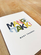 The "Mange Takk" Many Thanks in Norwegian Greeting Card (4.25" x 5.5") features colorful text and comes with a brown envelope. Blank inside for your personal note—perfect for expressing gratitude!.
