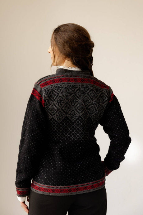 Back view of a black Norwegian knit cardigan featuring red and grey geometric patterns on the shoulders and cuffs, with a fleece lining.