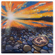 A bright sunset over a lake reflects vivid orange and blue hues. In the foreground, rocks line the shore alongside a Coaster: Discover Agates - Minnesota 4x4 in Absorbent Stone Coaster with Cork Back by Adam Turman sparkling in the sunlight.