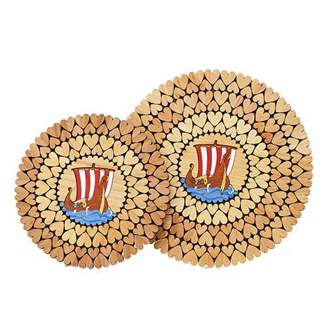 The Trivet: Colorful Viking Ship with Hearts (6") is made from alder and features a Nordic Viking design with heart-shaped pieces forming rings around a painted Viking ship with red sails at the center.