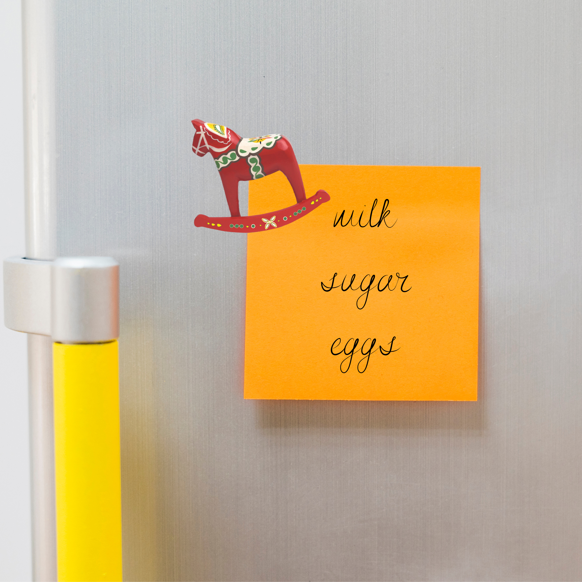 An orange sticky note on a fridge lists milk, sugar, and eggs beneath a decorative item styled as the "Magnet: Dala Horse 3D Fridge Magnet or Ornament.