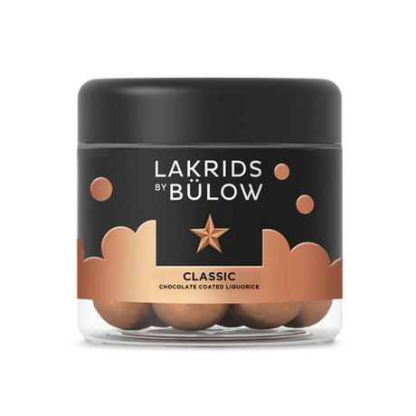 A 125g jar of Lakrids by Bülow Classic Caramel—Danish chocolate-coated licorice—offers a delicious gluten-free treat in labeled packaging with a black lid.