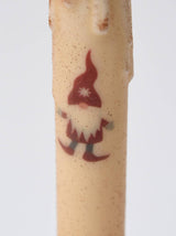 Close-up of the Candle: Christmas Gnome LED Timer Taper Candle: Cinnamon Dusted, showcasing a beige body with a gnome in a red hat and boots, white beard, and warm festive LED glow.