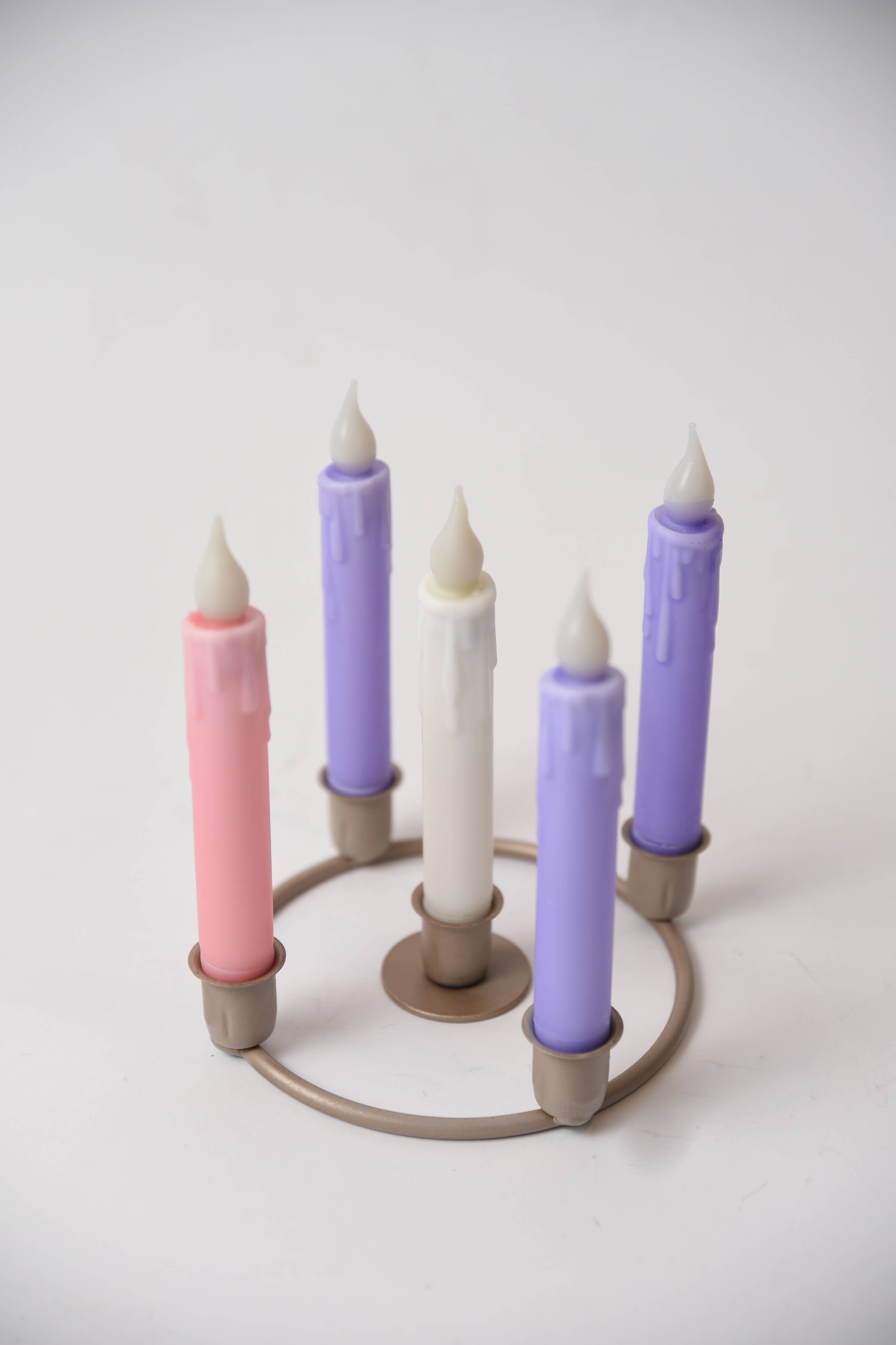 The Advent Candle Set with Holders includes five LED timer taper candles—three purple, one pink, and one white—arranged in a circular metal holder for safe, convenient holiday lighting.