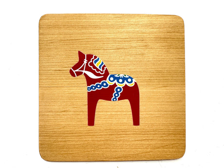 The 4" square alder wood coaster features a red Dala Horse with colorful kurbits, combining Swedish tradition and vibrant design.