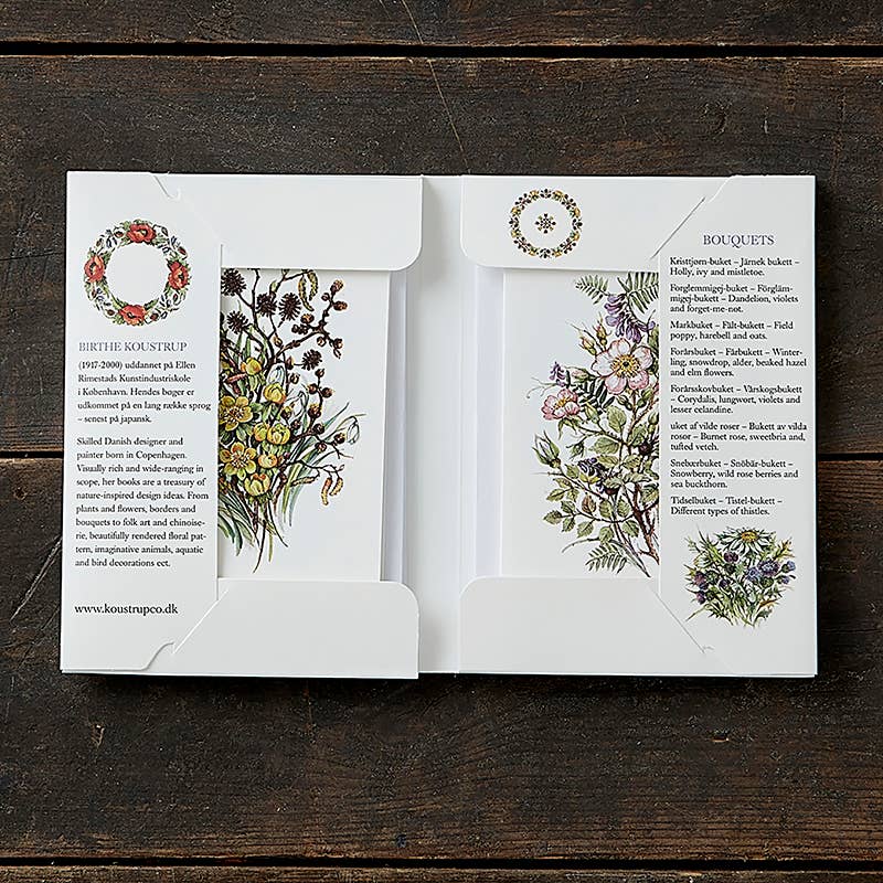 A set of Buketter greeting cards, featuring exquisite floral illustrations from the Card Pack: Bouquets collection, is elegantly displayed on a wooden surface, accompanied by eco-friendly envelopes.