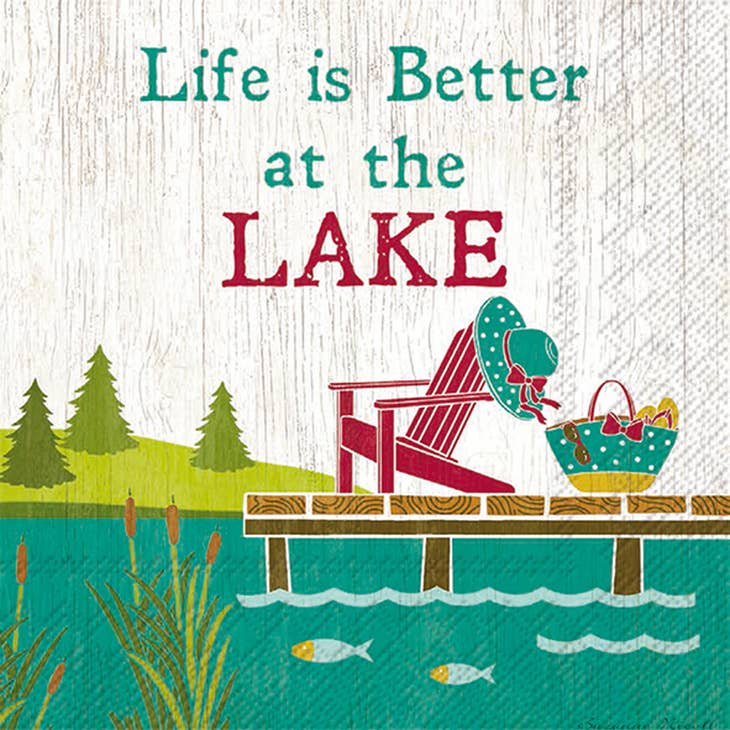 The "Napkins: Life is Better at the Lake" feature an illustration of a lakeside scene with a wooden chair, a hat, and a basket on a dock. The text reads "Better At The Lake," and two fish swim in the green water, creating that authentic Lake Life vibe perfect for cocktail napkins.