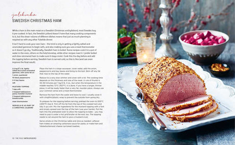 Sliced baked ham with a mustard and breadcrumb coating on a silver platter, Scandinavian style. Out-of-focus pink beet salad in the background.
