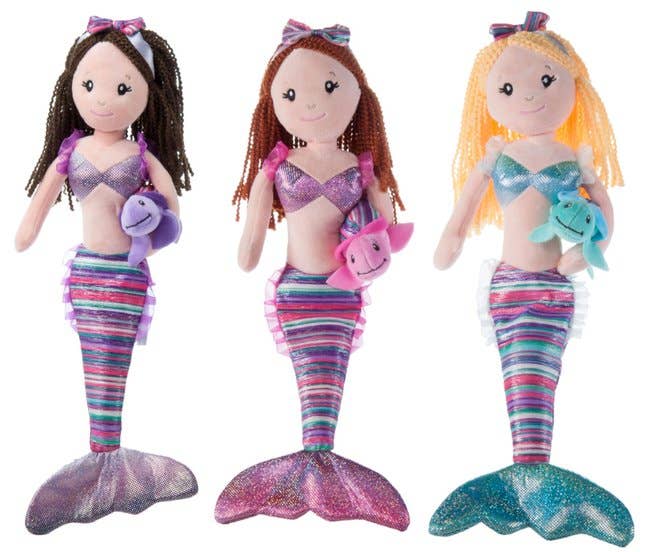 Three Plush: Mermaid Boho Mermaid dolls with colorful tails and starfish hair accessories delight young imaginations. Each mermaid doll holds a small plush sea creature—purple dolphin, pink dolphin, and blue fish from left to right—and features a removable sea turtle toy for added playtime fun.